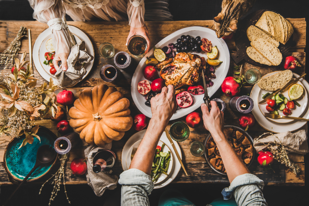 Thanksgiving table with roasted chicken and vegetables — holiday foods dangerous to pets