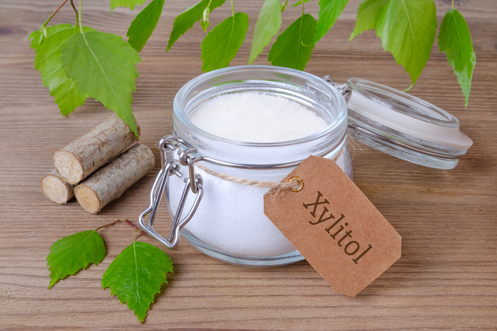 Xylitol sugar substitute in a glass jar with birch leaves — toxic to pets warning
